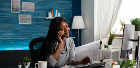 Businesswoman talking on phone call and looking at papers