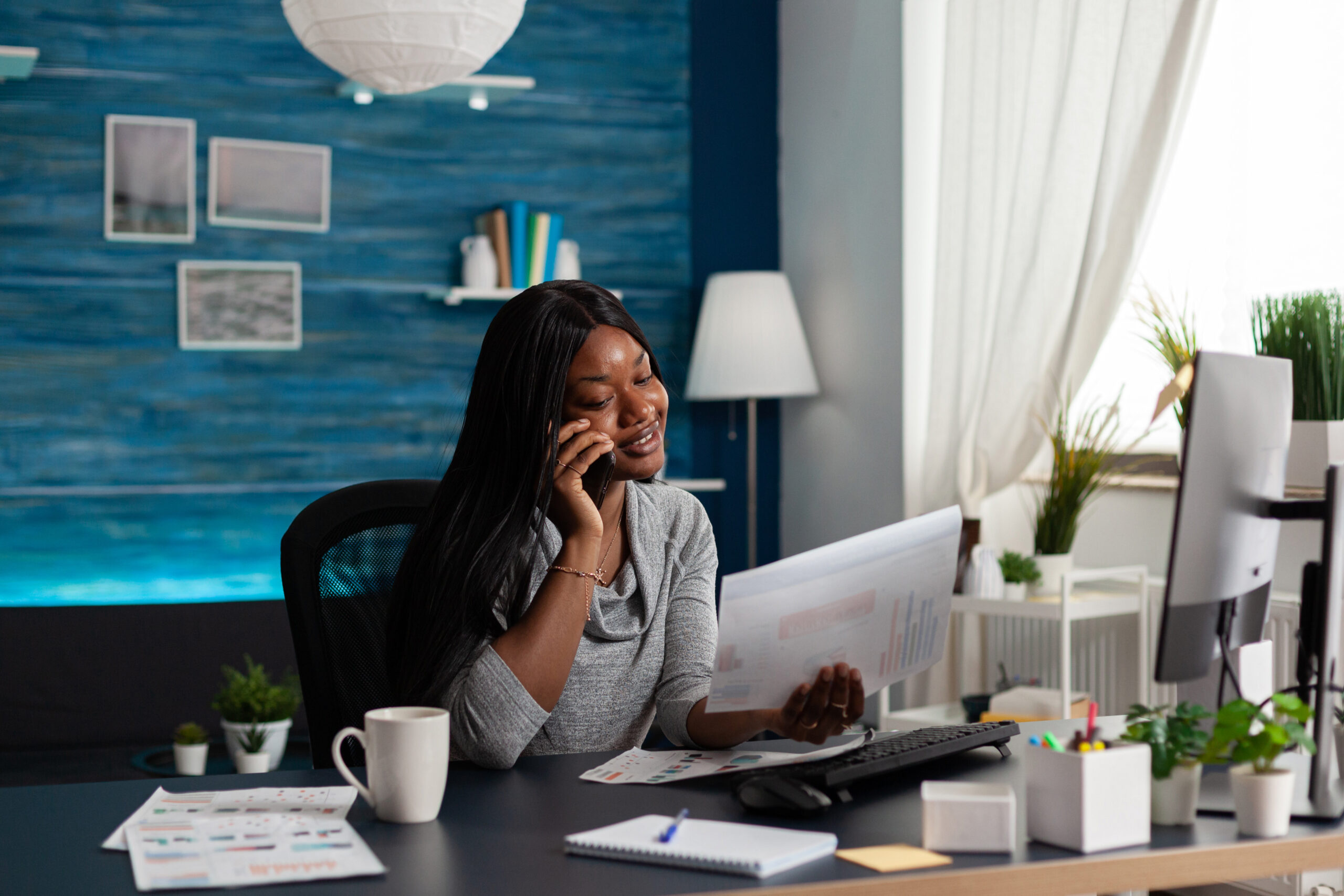 Businesswoman talking on phone call and looking at papers