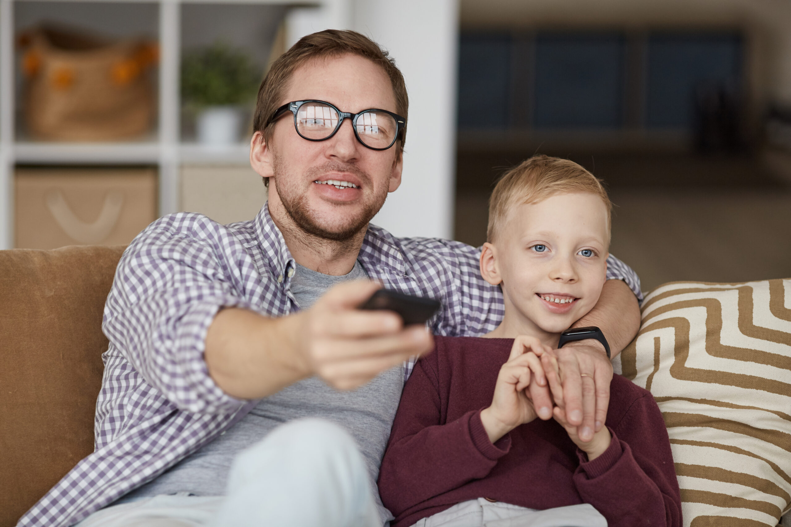 Father watching educational TV shows with son