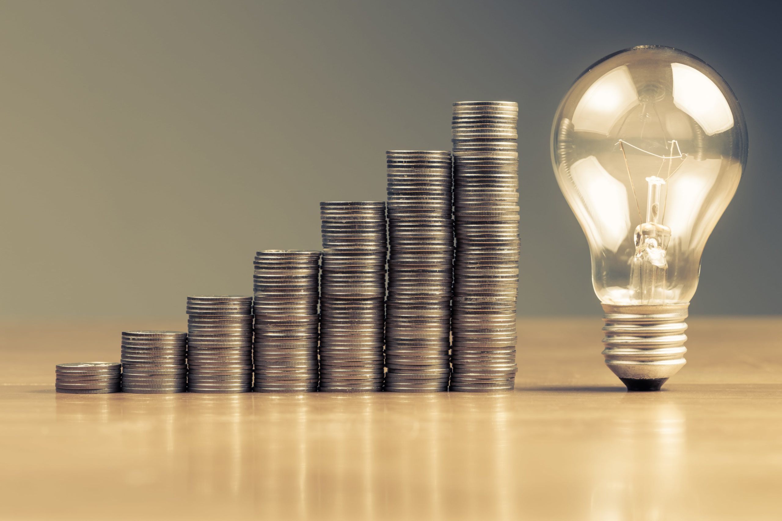 stack of coins leading up to light bulb min