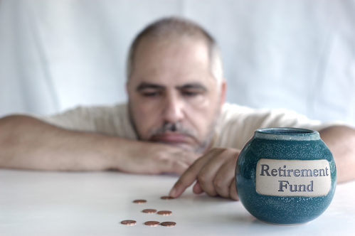 man counting coins next to retirement fund