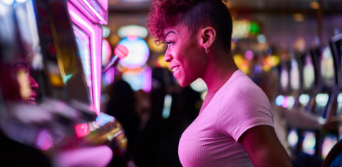 happy woman gambling at a casino slot machine