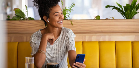 woman on the phone sitting at a cafe