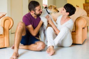 Man and woman in they house playing with the dog