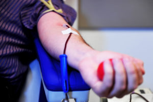 The hand of a blood donor squeezing a medical rubber ball