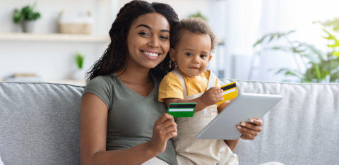 woman holding a baby and a credit card