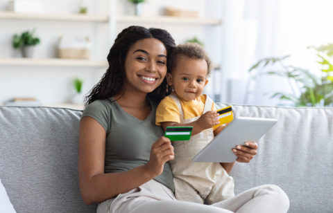 woman holding a baby and a credit card