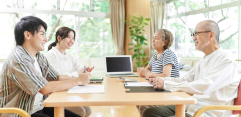 Young couple speaking to retired parents about reverse mortgages