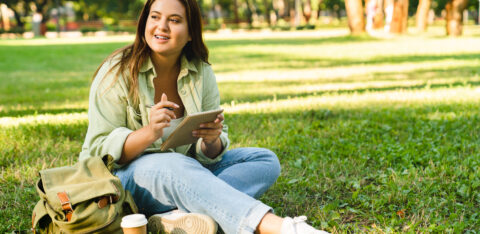 Student doing homework, e learning, preparing for test exam writing poems on college university park