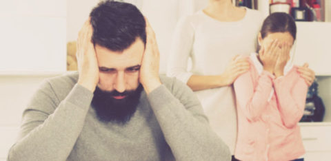 distressed man with family standing behind him