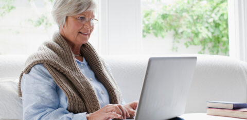 Smiling older woman using laptop