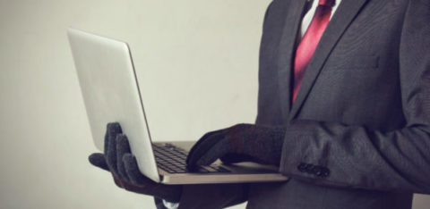 man with gloves using a computer