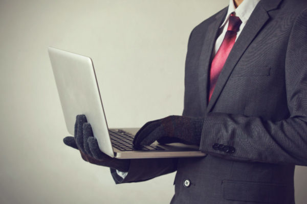 man with gloves using a computer