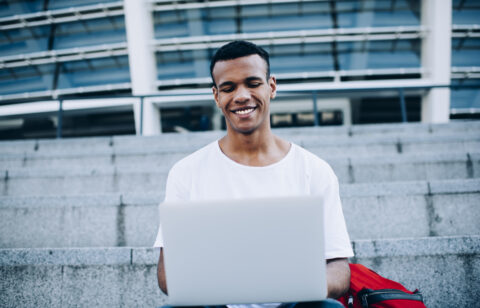 guy with laptop sitting on steps