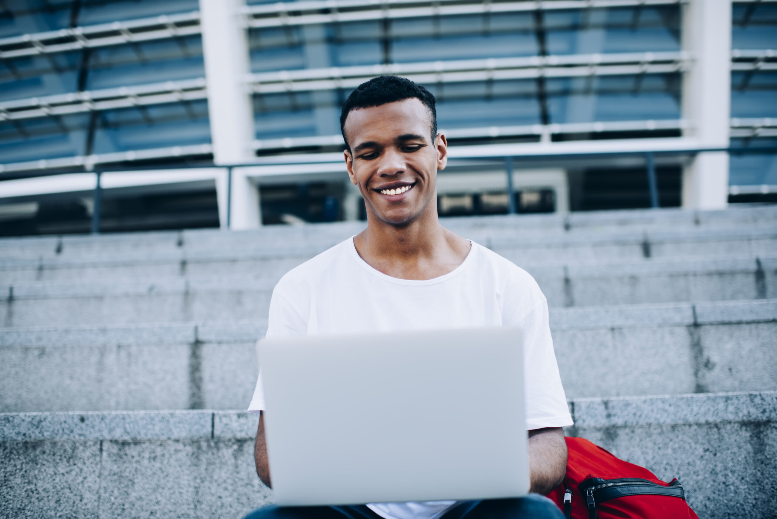 guy with laptop sitting on steps