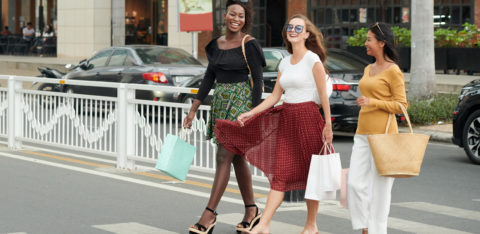 three women shopping while in debt