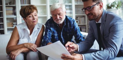 an older couple asking questions to a man holding a piece of paper