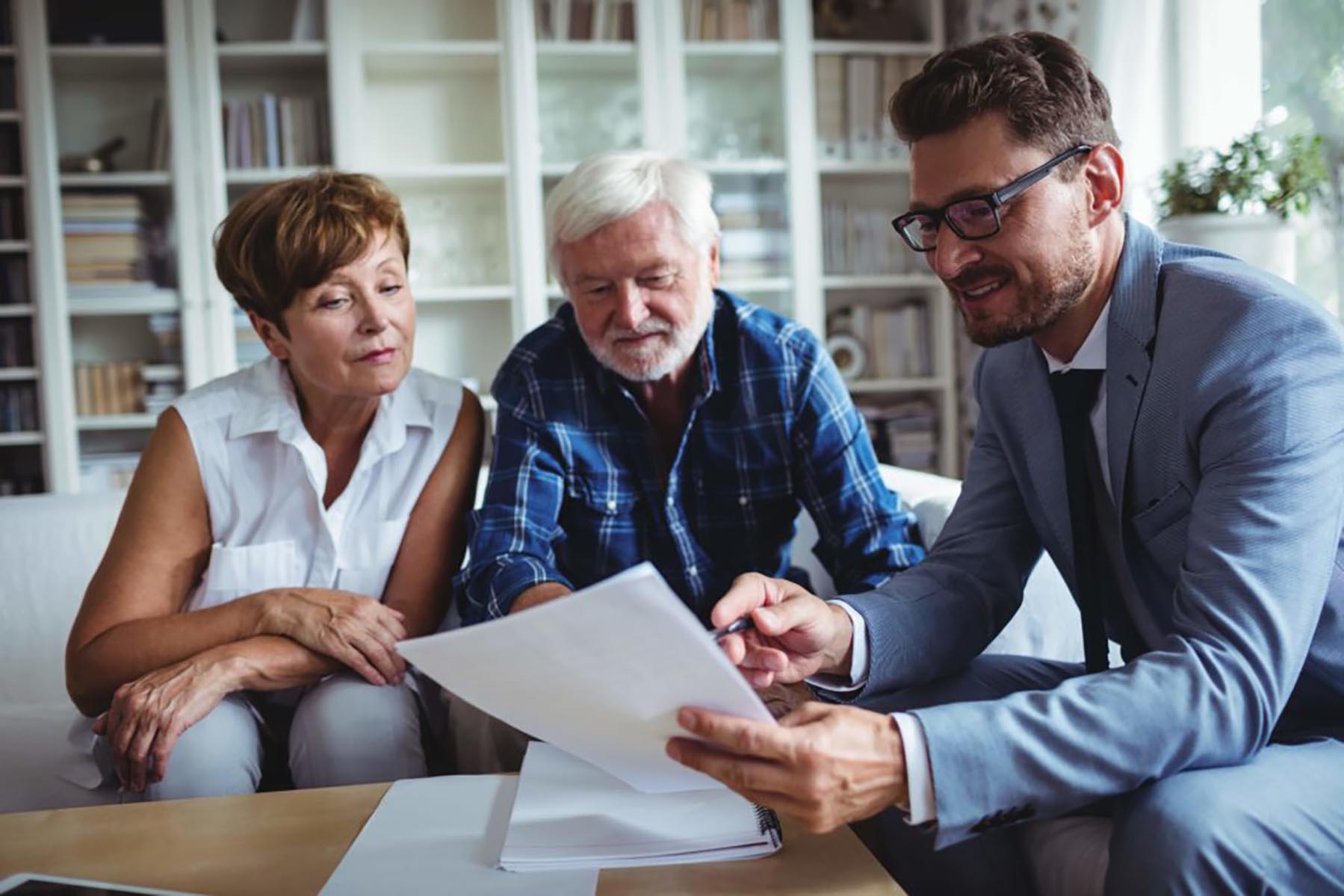 an older couple asking questions to a man holding a piece of paper