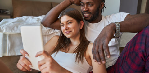 happy couple watching something on tablet