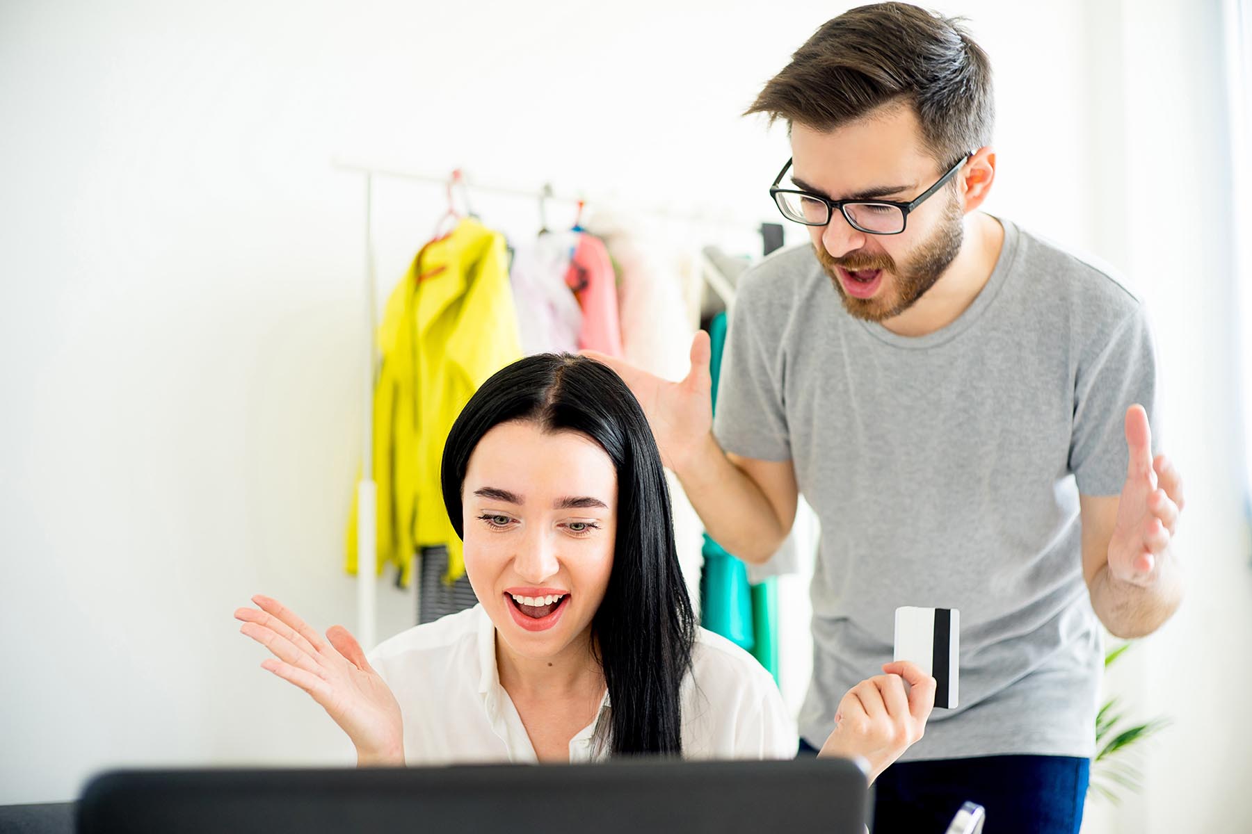 couple arguing at computer over spouse being bad with money