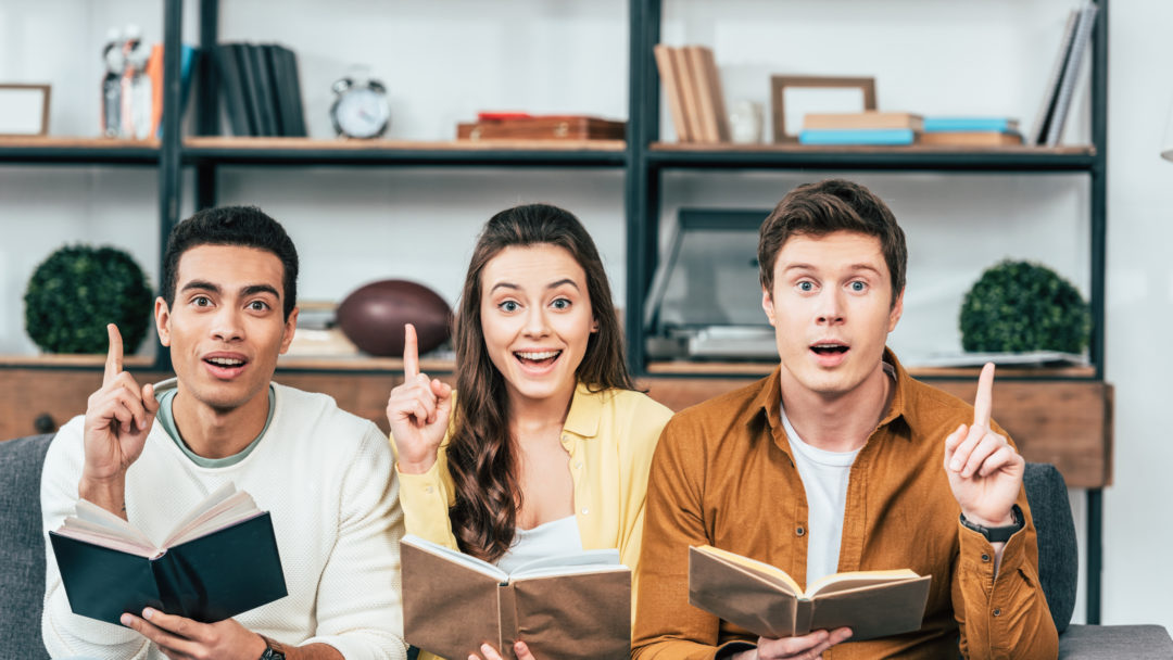 three people holding books