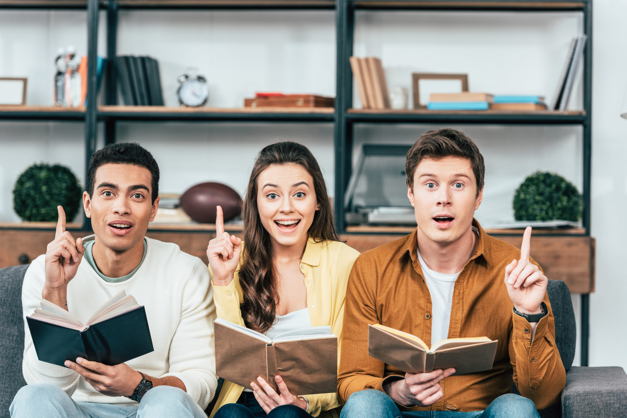 three people holding books