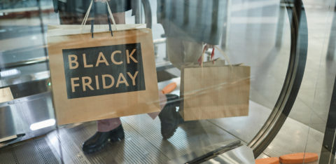 person holding a black Friday shopping bag