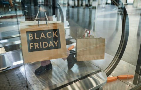 person holding a black Friday shopping bag