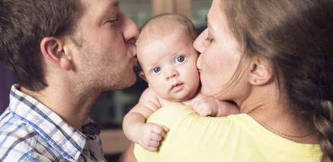 Mom and dad kissling baby