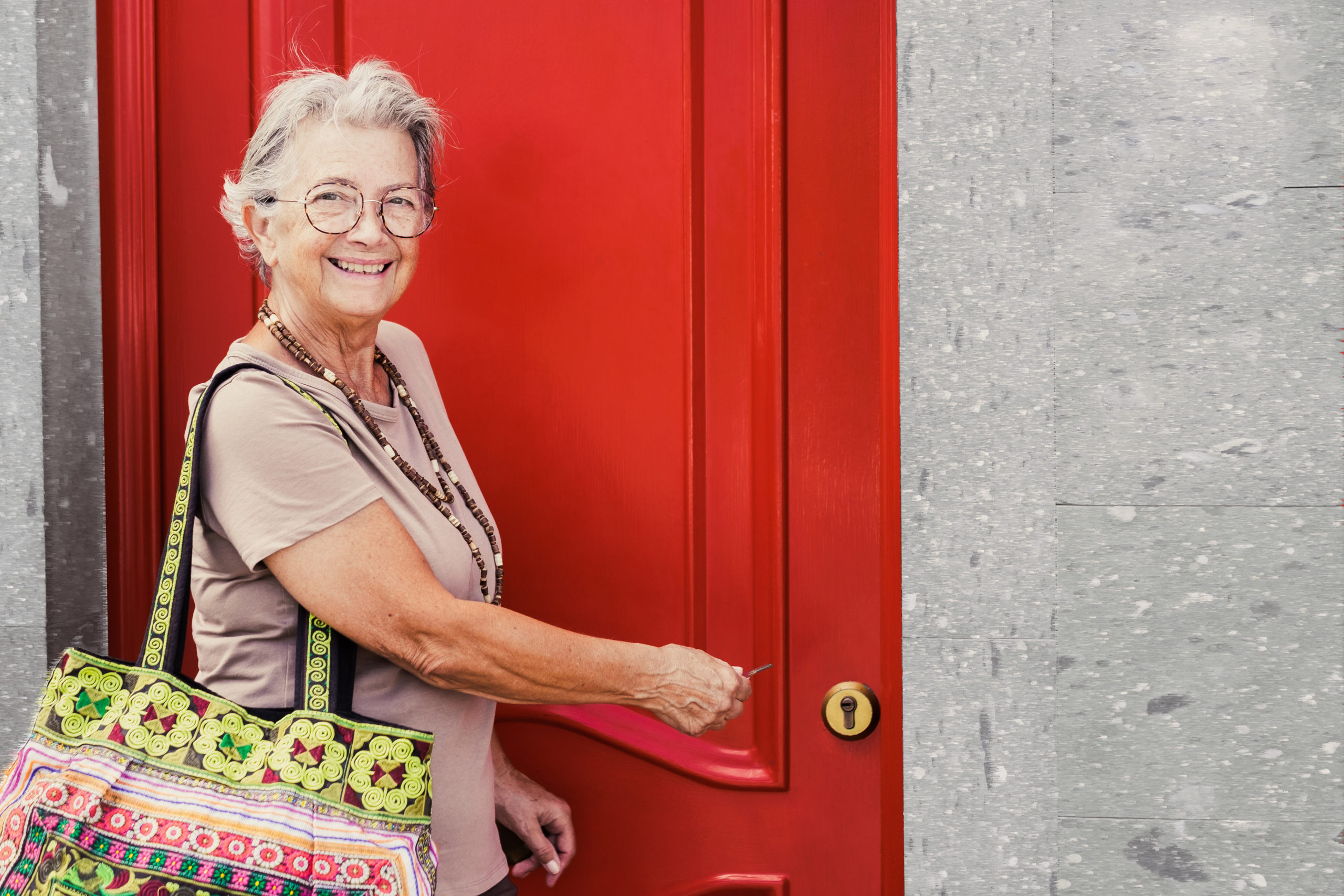 female homeowner opening a red door to her home