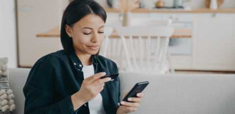 smiling woman calculating debt-to-credit ratio