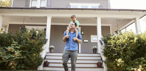 Father Giving son ride on shoulders outside home