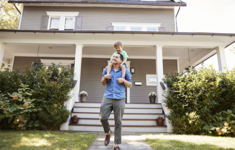 Father Giving son ride on shoulders outside home