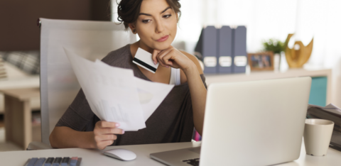 Pensive woman paying bills at home