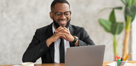 Smiling black man watching video on computer