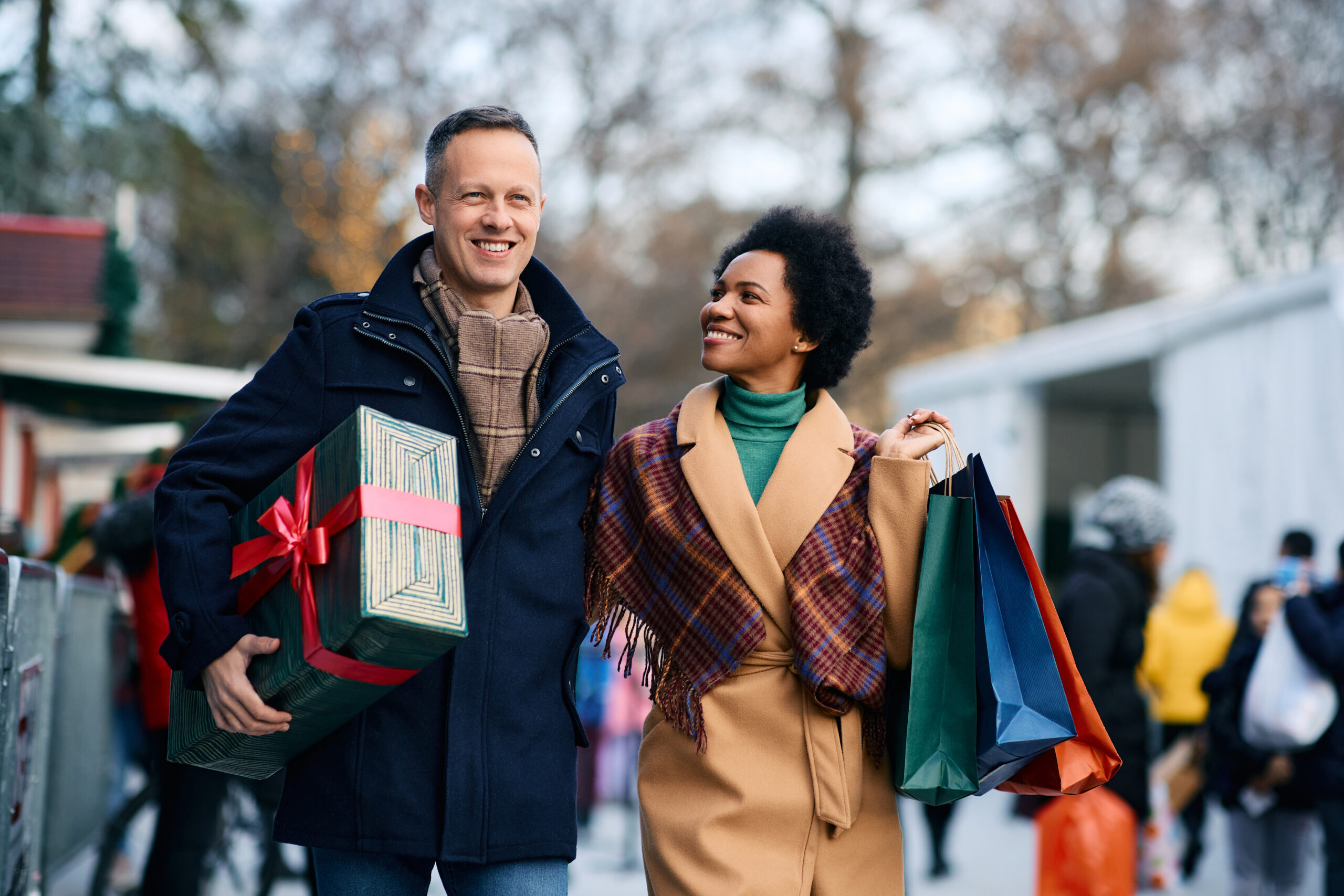 Happy multiracial couple enjoying in Christmas shopping.