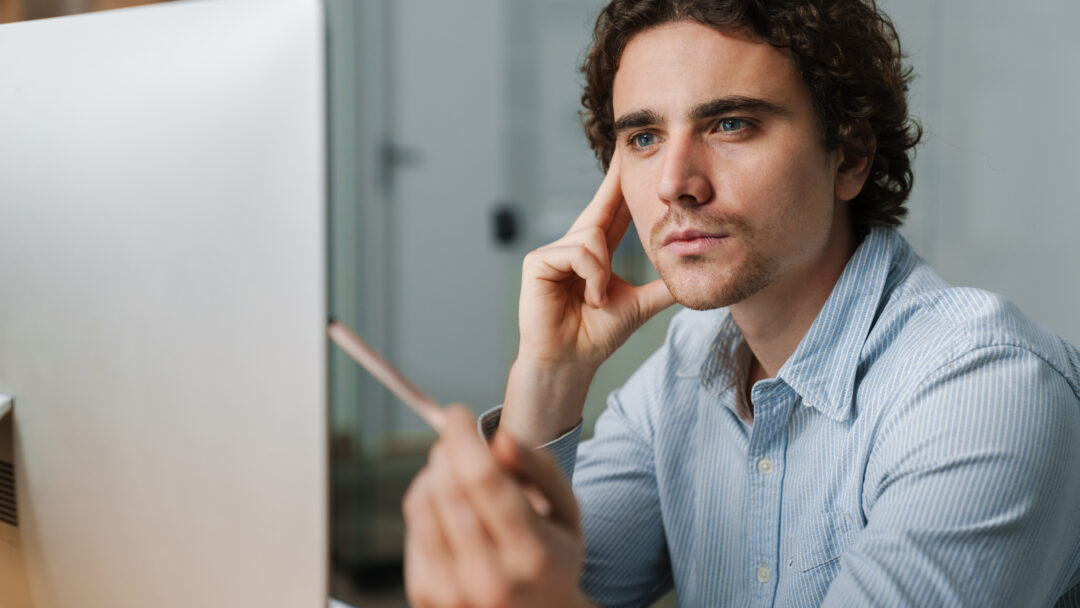 Confident young busy entrepreneur sitting at the office desk