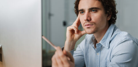 Confident young busy entrepreneur sitting at the office desk