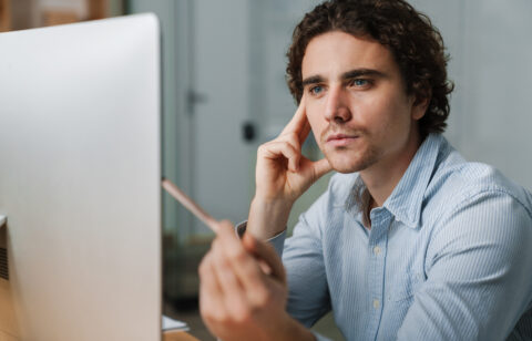 Confident young busy entrepreneur sitting at the office desk