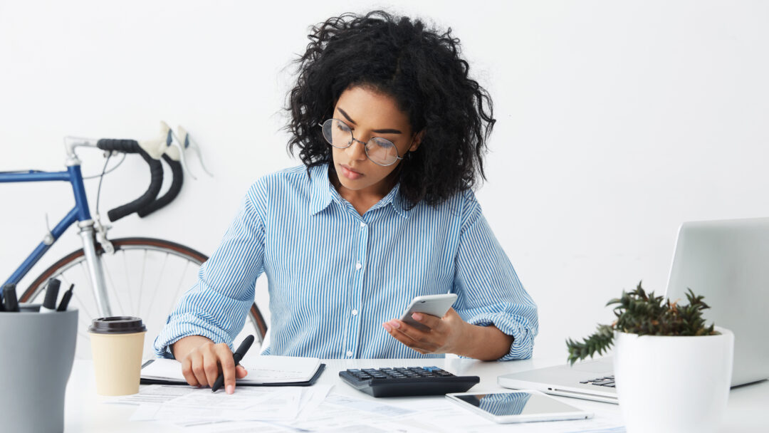 woman filing taxes with calculator and notepad