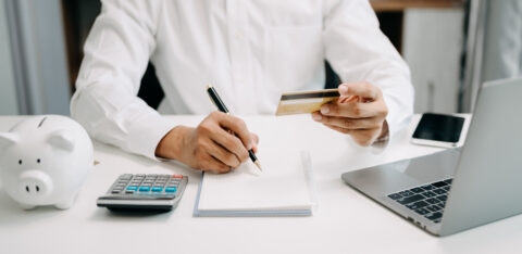 Businessman using calculator with credit card for shopping inter