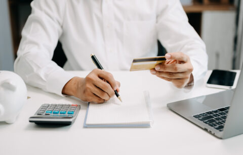 Businessman using calculator with credit card for shopping inter