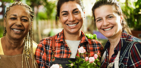 Multiracial senior women working inside greenhouse garden Focus on center female face