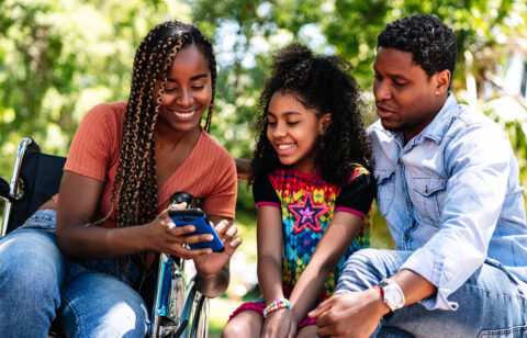 Woman in a wheelchair at the park with family.