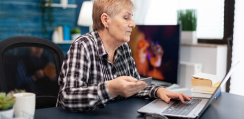 Positive senior woman paying bills