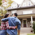 Man and woman in front of recently purchased home