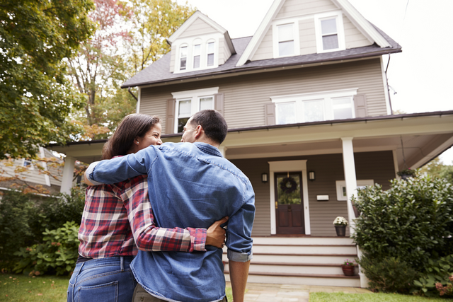 Man and woman in front of recently purchased home