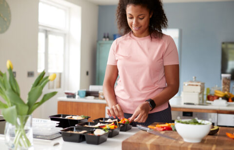 Woman Preparing Batch Of Healthy Meals At Home In Kitchen